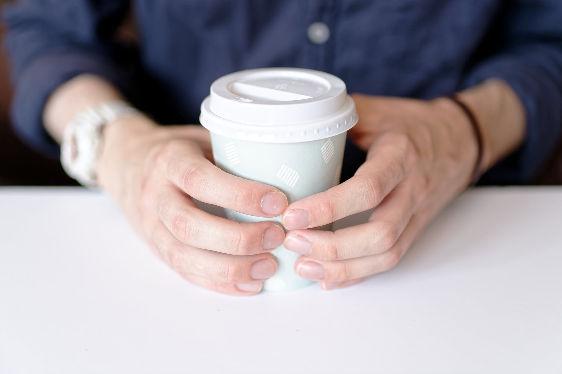photo of person holding white paper cup