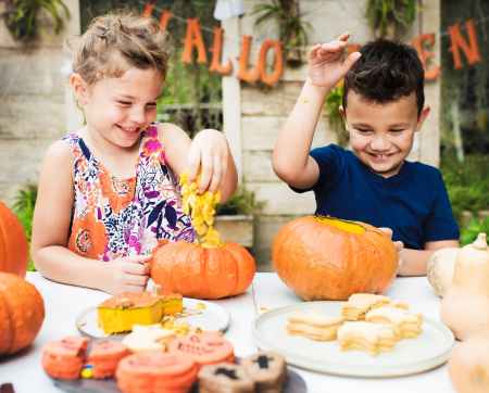 boy and girl playing with pumpkins