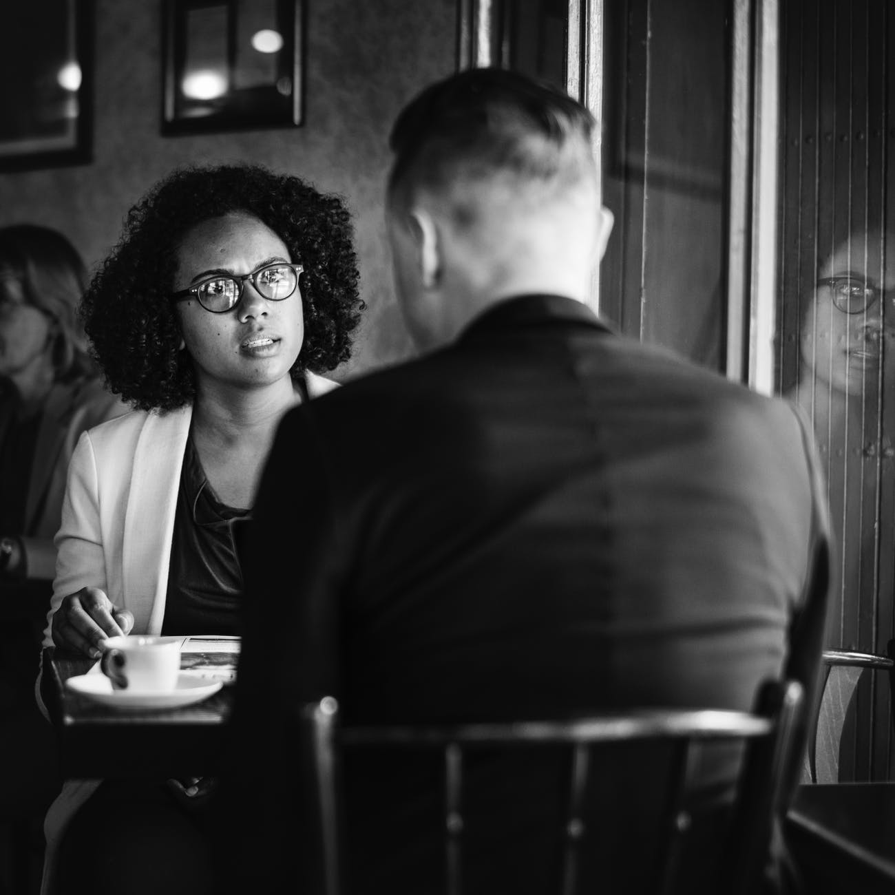 man and woman talking to each other while sitting on chair