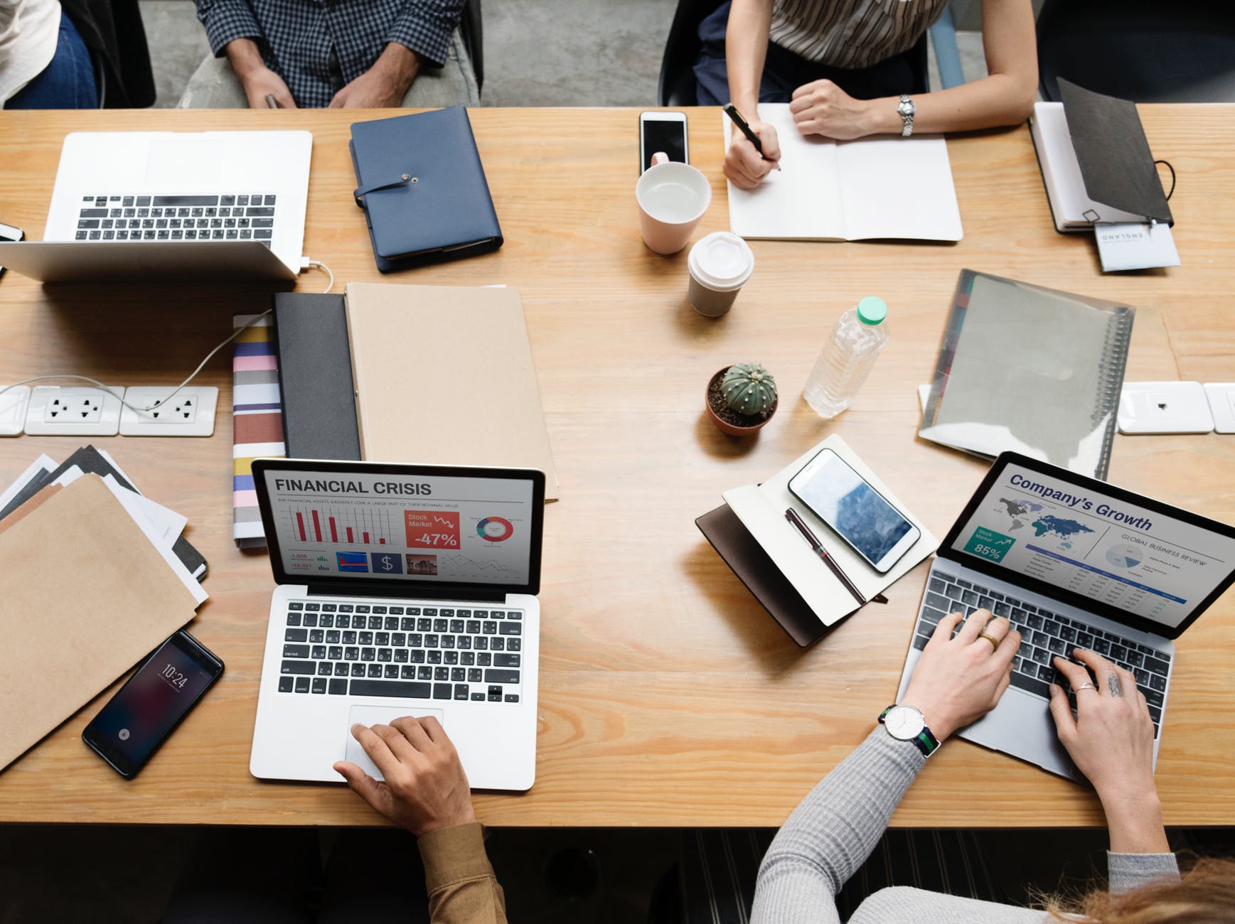 flat view photography of four persons sitting facing laptop on desk