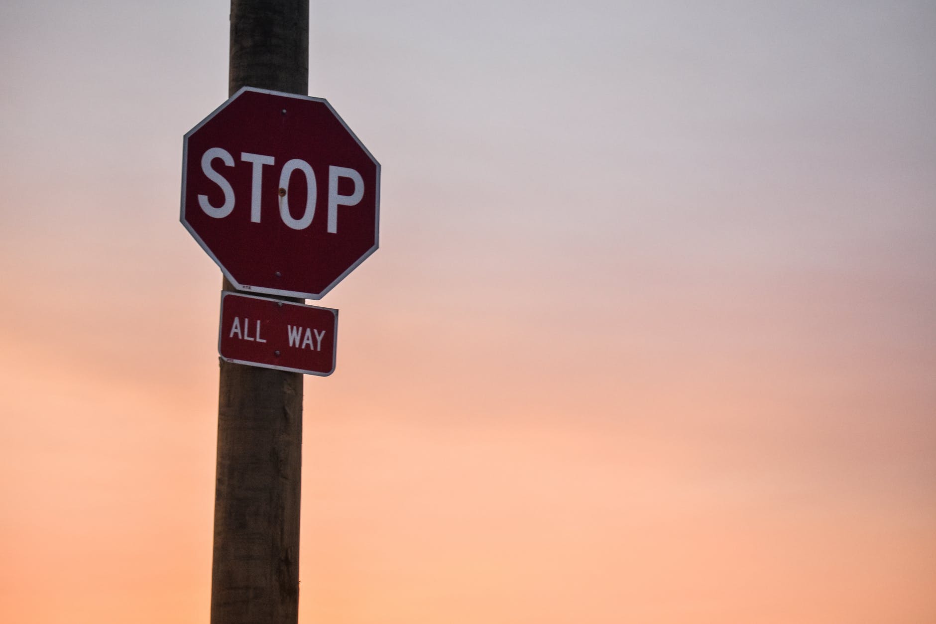 stop signage under orange sky