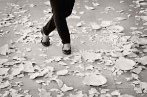grayscale of woman in black flat sandals walking