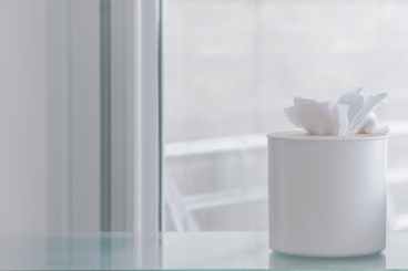 tissue paper on container near glass window