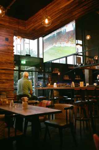 man wearing green polo shirt sitting in front of wooden counter