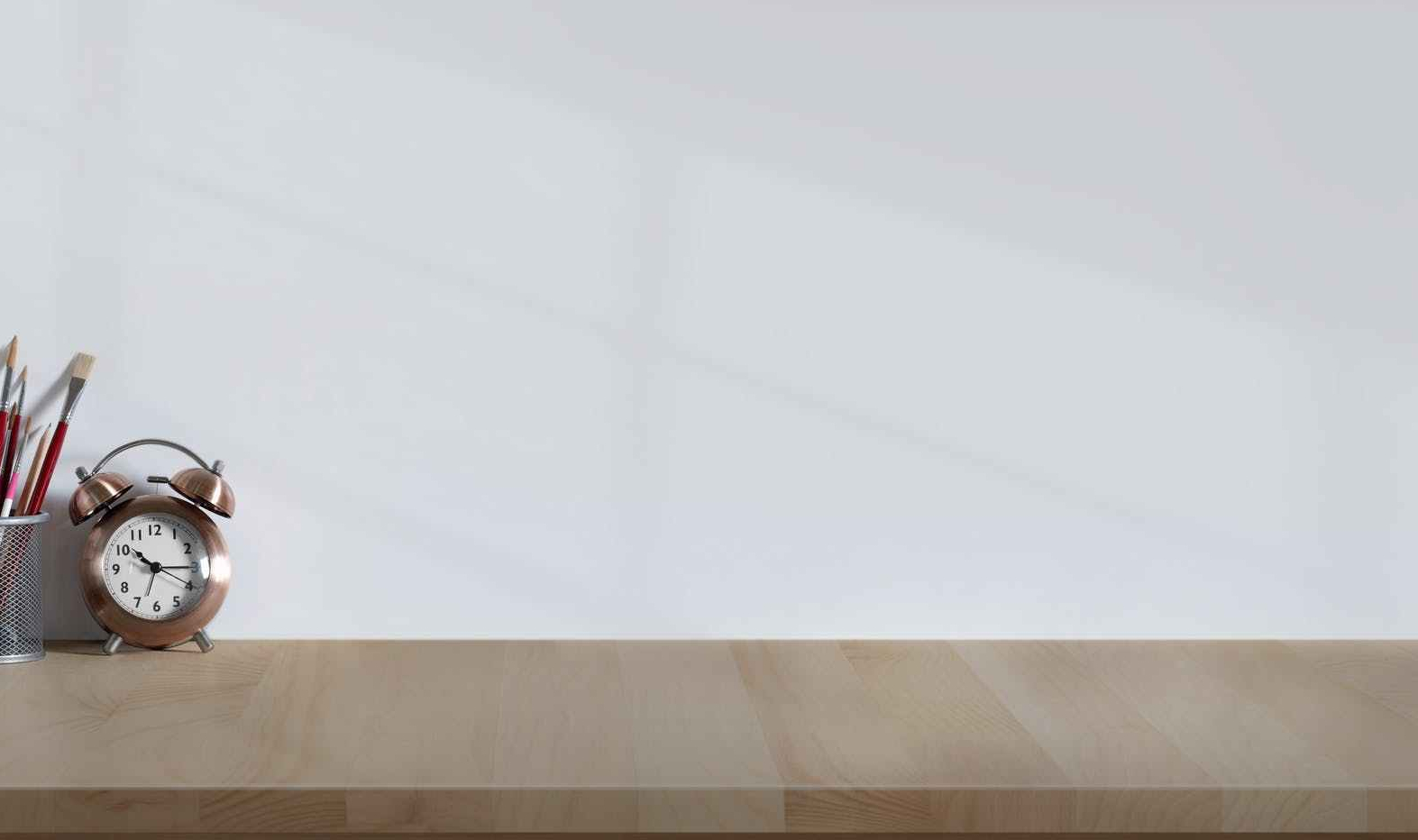 alarm clock and analog camera on wooden desk