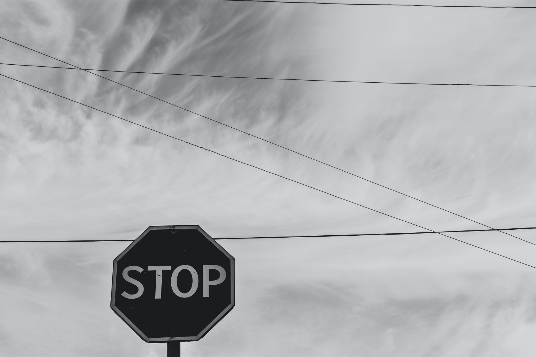 grayscale photography of stop signage under sky